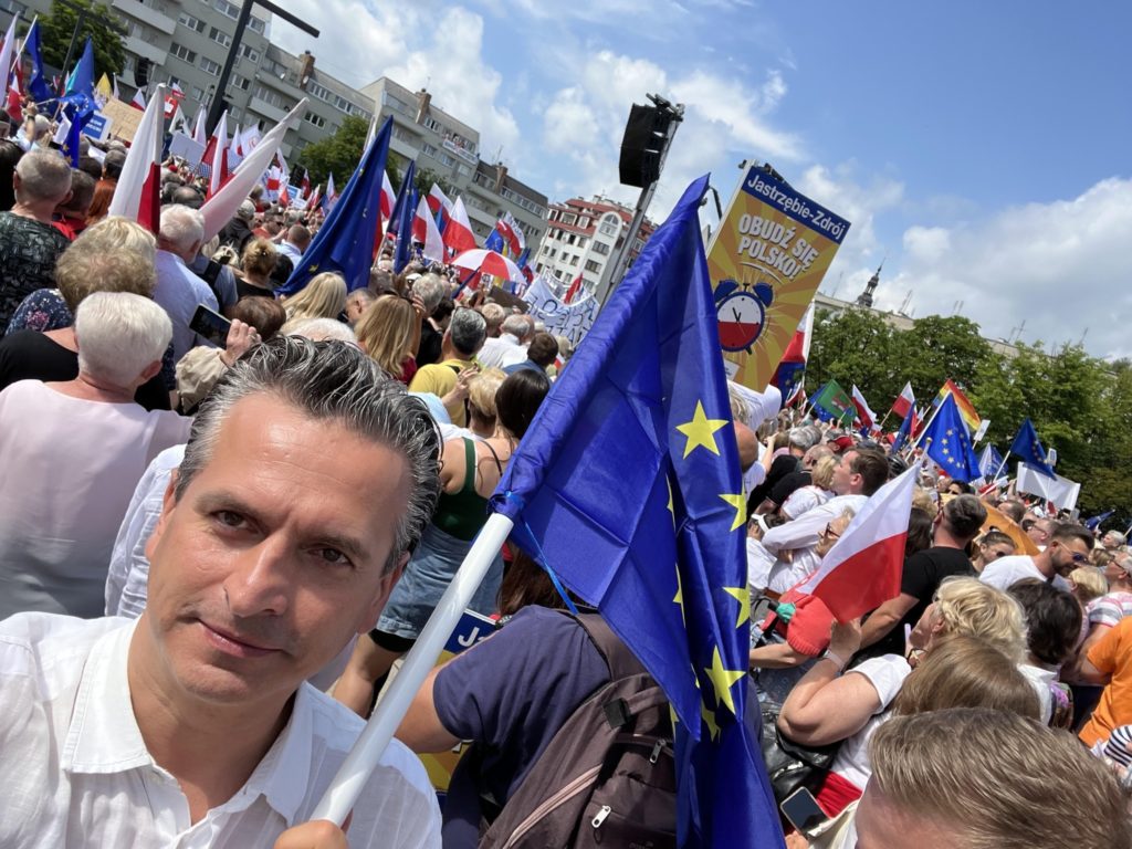 Robert Wardzała wśród uczestników zgromadzenia z flagami