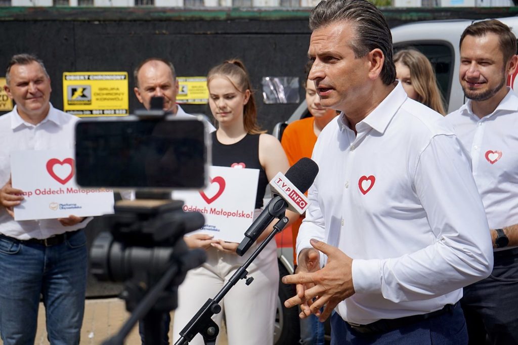 Robert Wardzała mówi do mikrofonów podczas konferencji plenerowej
