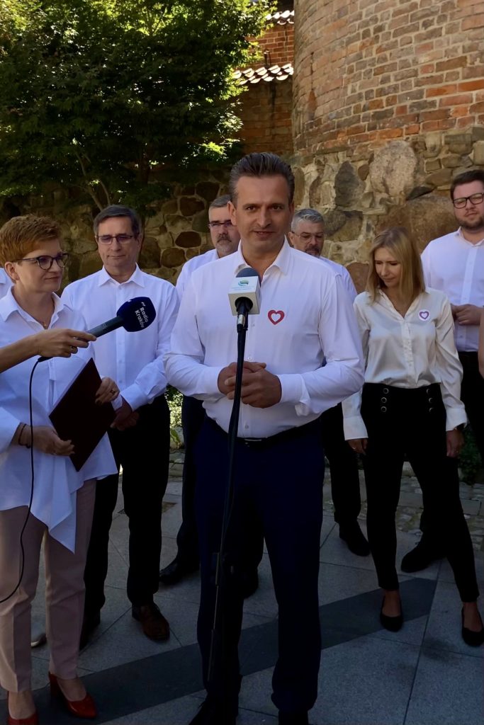 Robert Wardzała podczas wypowiedzi przed mikrofonami w plenerze