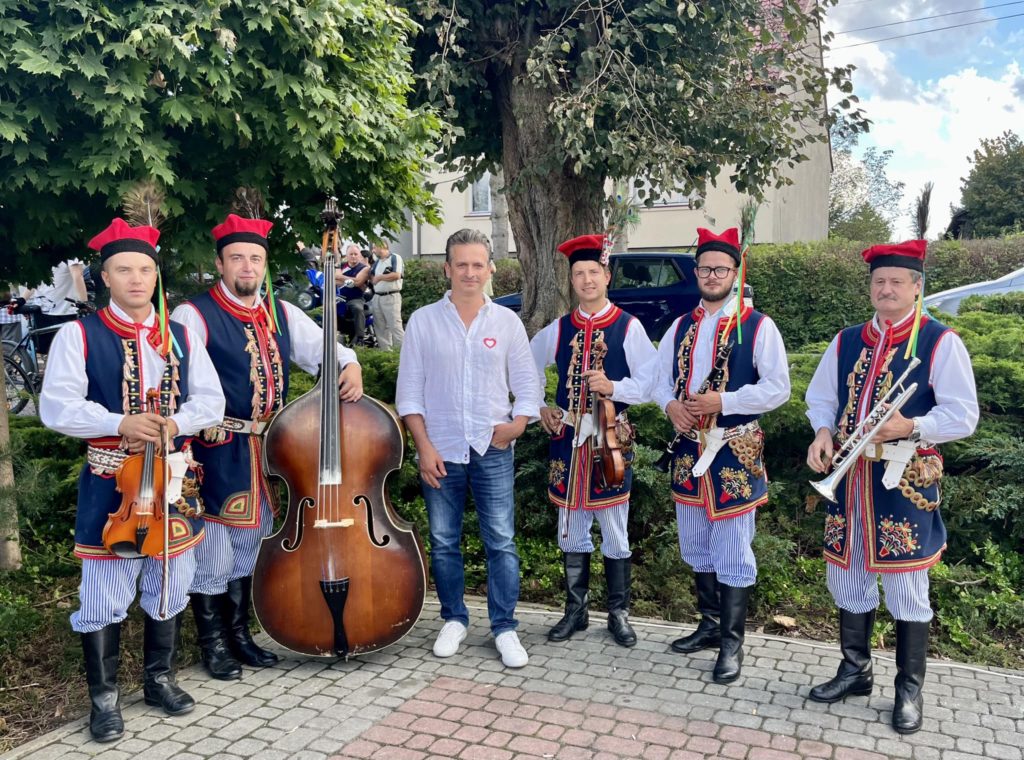 Robert Wardzała z muzykami w strojach ludowych