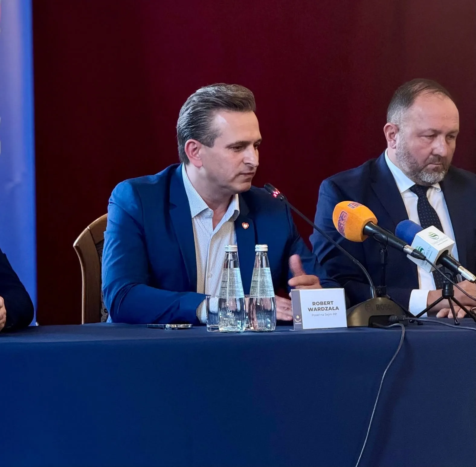 Robert Wardzała — przy stole z mikrofonami podczas spotkania