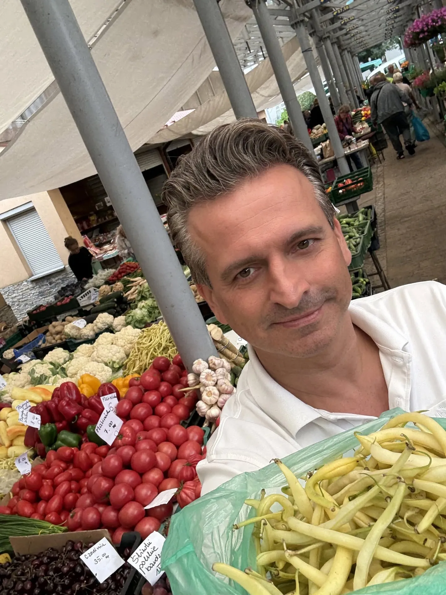 Robert Wardzała — z torbą fasolki przy stoisku z warzywami